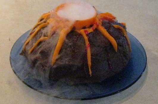 Add a little water to dry ice to make a smoking volcano effect on a cake. You can use red jello or tinted icing if you want 'lava' to flow down the sides of the cake.