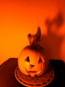 Shine a low pressure sodium lamp on a flame colored with table salt for a black flame pumpkin.