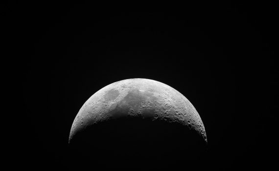 The moon rotates, completing one rotation each month so we only see one side.
